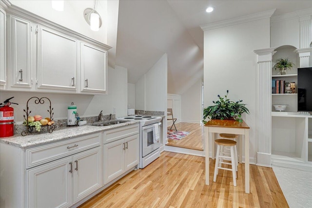 kitchen featuring ornate columns, sink, white range with electric stovetop, light hardwood / wood-style floors, and white cabinets