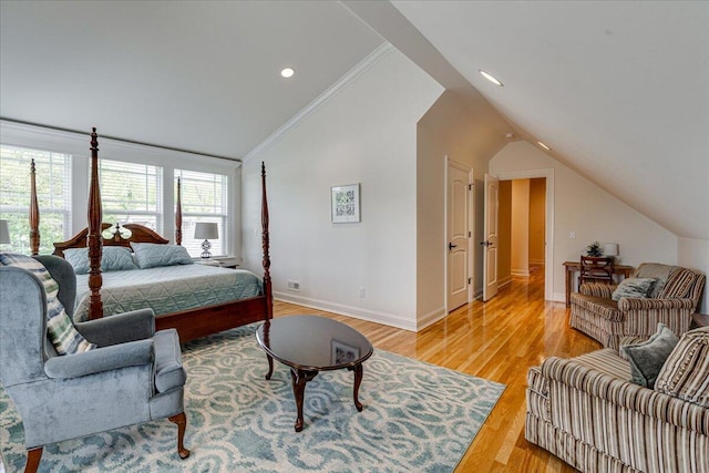 bedroom with vaulted ceiling, ornamental molding, and light hardwood / wood-style flooring