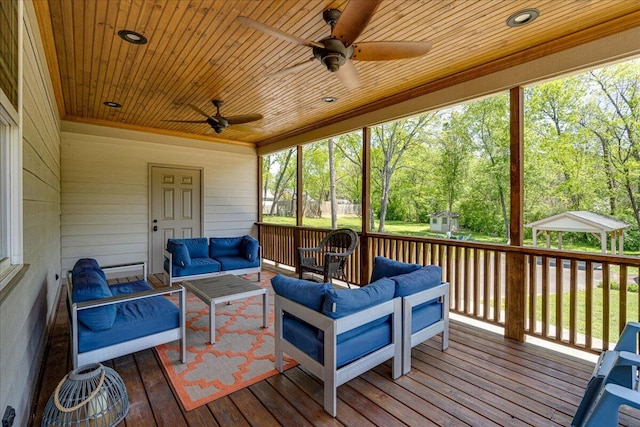 wooden terrace featuring an outdoor living space and ceiling fan