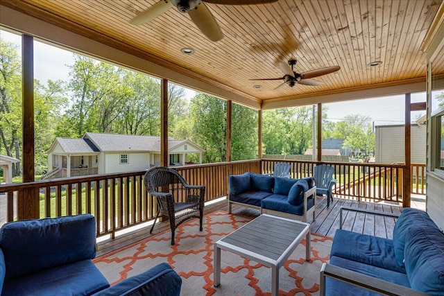 sunroom / solarium featuring ceiling fan, plenty of natural light, and wooden ceiling