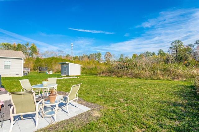 view of yard featuring a patio area, a trampoline, and a shed