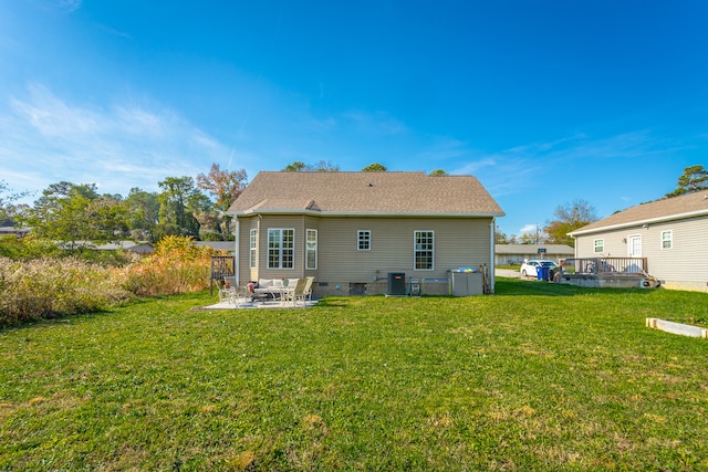 rear view of house featuring cooling unit, a yard, and a patio