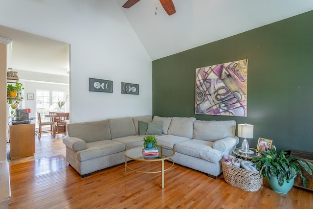 living room featuring ceiling fan, light wood-type flooring, and high vaulted ceiling