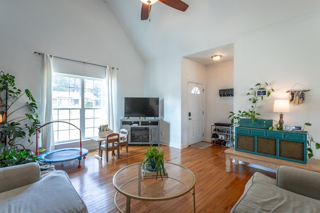 living room with hardwood / wood-style floors, high vaulted ceiling, and ceiling fan