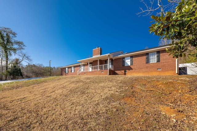 back of property featuring a porch and a lawn