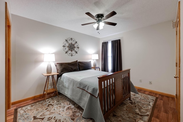 bedroom with ceiling fan, hardwood / wood-style floors, and a textured ceiling