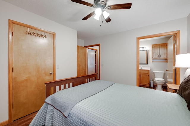 bedroom featuring ceiling fan, ensuite bathroom, and hardwood / wood-style flooring