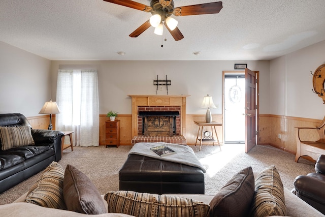 living room with a wealth of natural light, light colored carpet, a brick fireplace, and wood walls