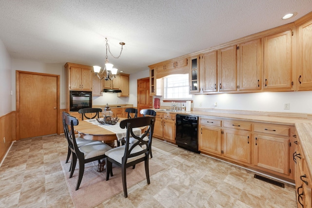 kitchen with a textured ceiling, decorative light fixtures, black appliances, an inviting chandelier, and sink