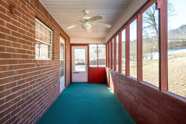 unfurnished sunroom with ceiling fan