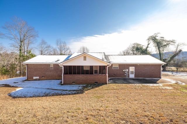 back of house featuring a lawn and a sunroom