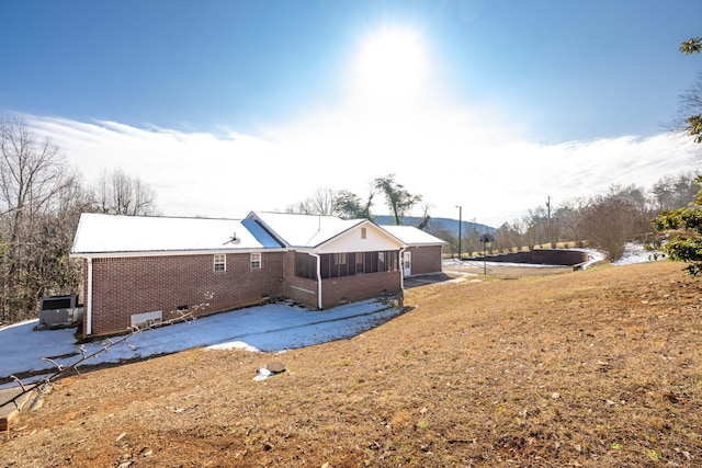 rear view of house featuring a lawn and a sunroom