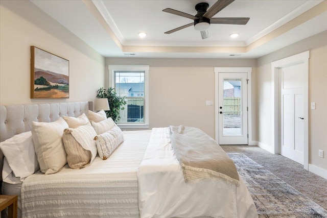 carpeted bedroom featuring ceiling fan, access to exterior, and a raised ceiling