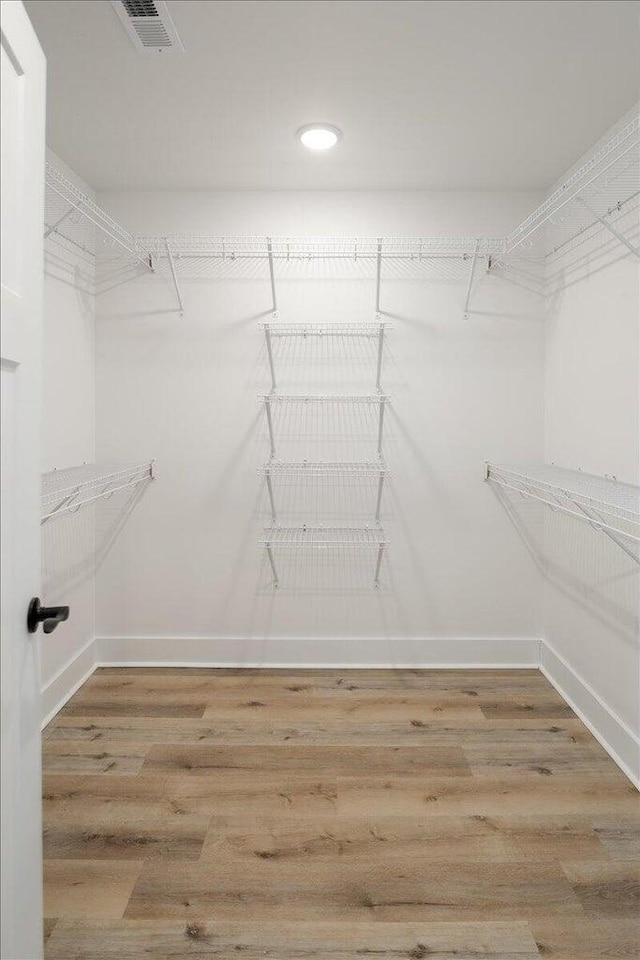 spacious closet with hardwood / wood-style flooring