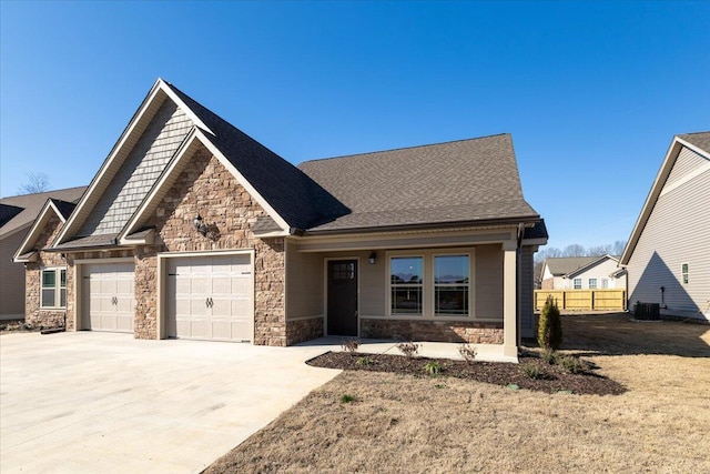 craftsman inspired home featuring a garage and cooling unit