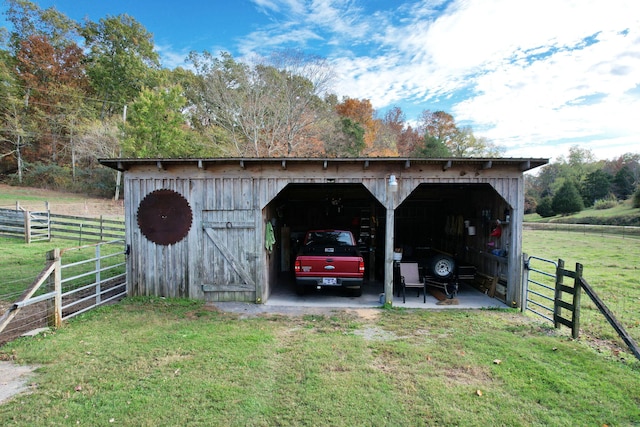 view of outdoor structure with a rural view and a lawn