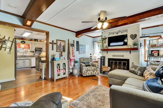 living room with ceiling fan, crown molding, light hardwood / wood-style floors, and beamed ceiling