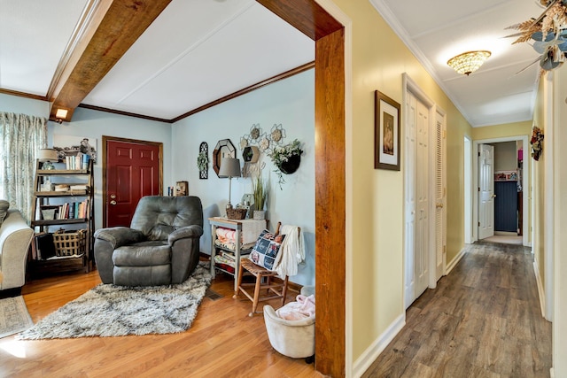 hall featuring ornamental molding, wood-type flooring, and beamed ceiling