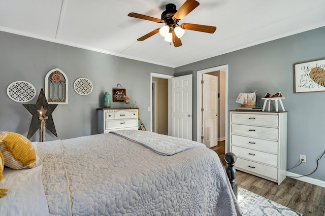 bedroom with crown molding, ceiling fan, and dark hardwood / wood-style floors