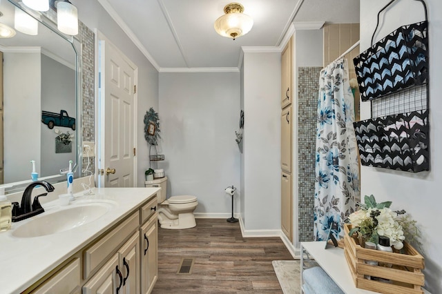 bathroom with ornamental molding, a shower with curtain, vanity, hardwood / wood-style floors, and toilet