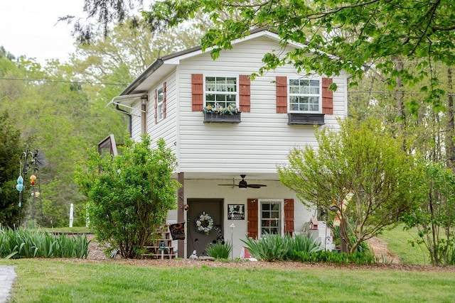 traditional home featuring a front lawn and a ceiling fan