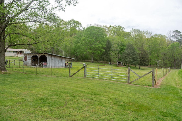 view of yard with a gate, an outdoor structure, fence, and a pole building