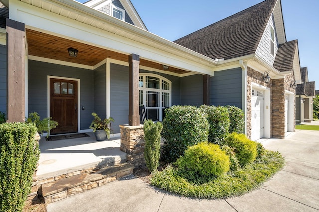 entrance to property featuring covered porch and a garage