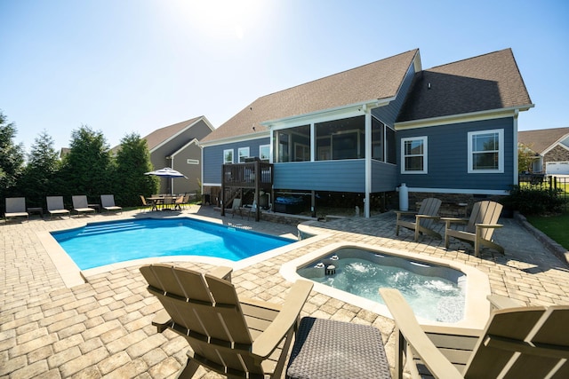 view of swimming pool featuring a jacuzzi, a patio, and a sunroom