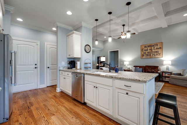 kitchen featuring appliances with stainless steel finishes, light hardwood / wood-style floors, coffered ceiling, and sink