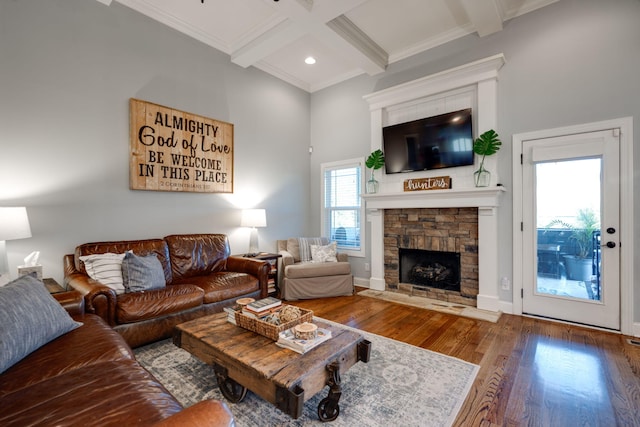 living room with coffered ceiling, hardwood / wood-style flooring, ornamental molding, a fireplace, and beam ceiling