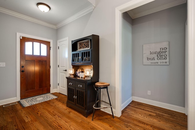 foyer featuring dark hardwood / wood-style floors and crown molding