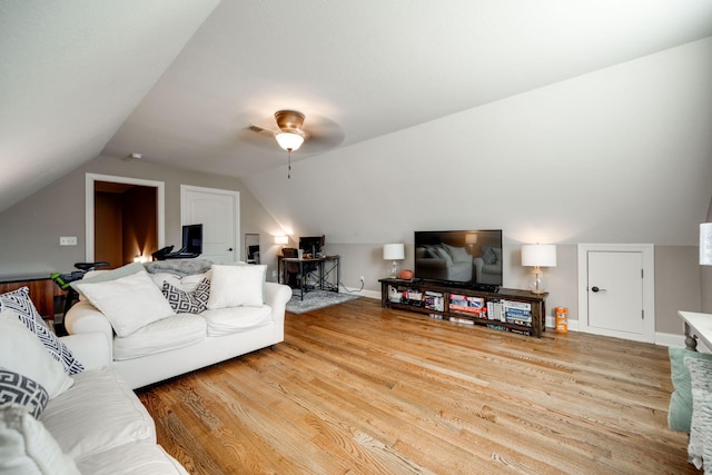 living room with ceiling fan, hardwood / wood-style floors, and vaulted ceiling