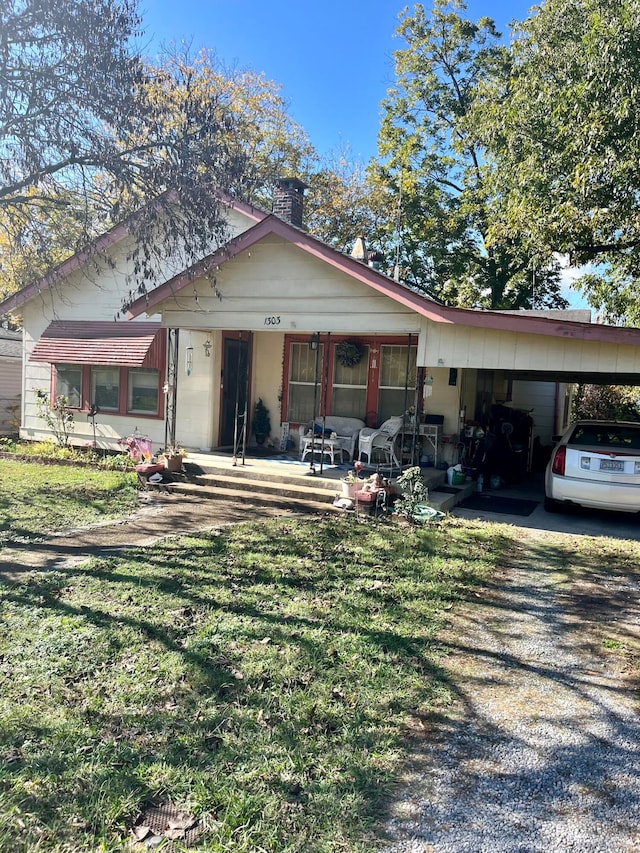 view of front of house featuring a porch, a front yard, and a carport