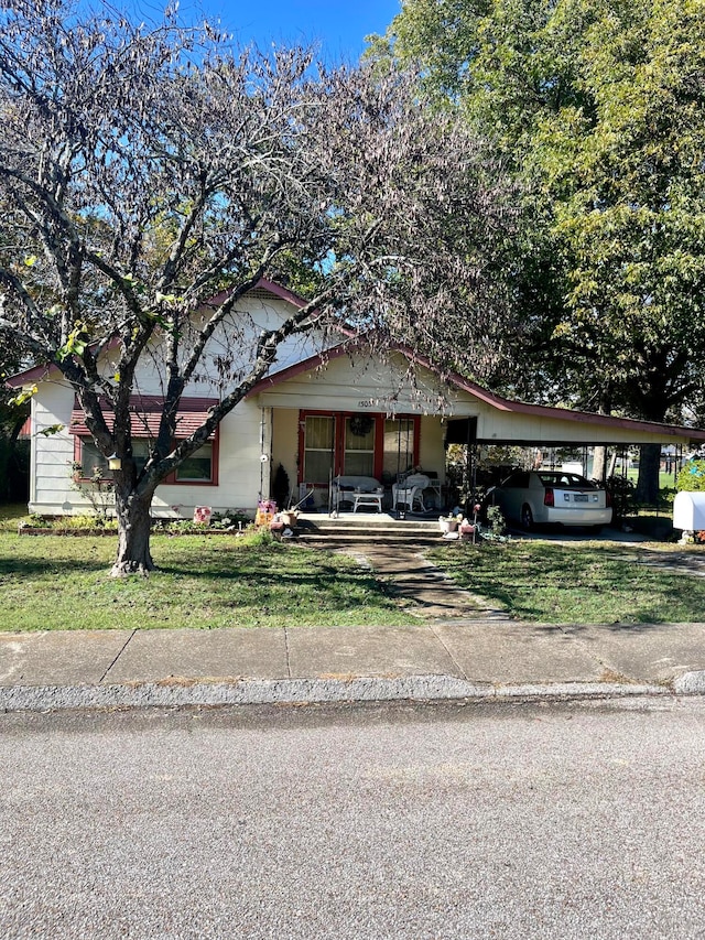 view of front facade with a porch, a front lawn, and a carport