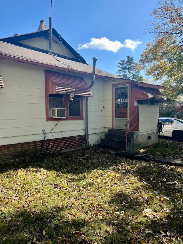 view of side of home featuring a lawn and cooling unit