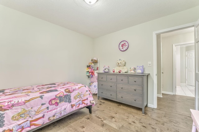 bedroom featuring light hardwood / wood-style flooring and a textured ceiling