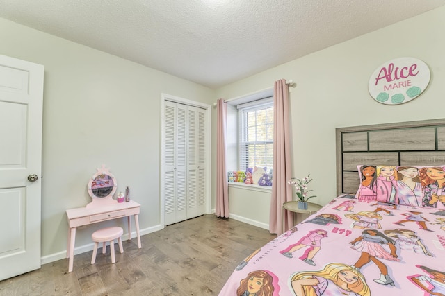 bedroom featuring a closet, a textured ceiling, and light hardwood / wood-style floors