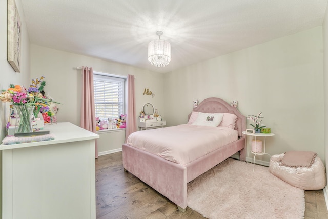 bedroom featuring an inviting chandelier and light wood-type flooring