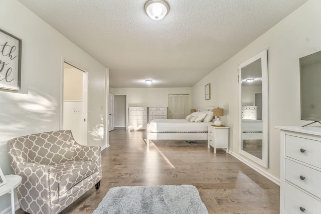 bedroom with a textured ceiling and hardwood / wood-style flooring