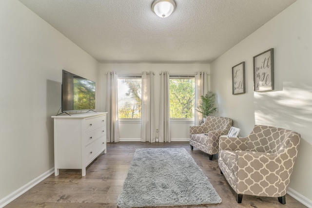 living area with hardwood / wood-style flooring and a textured ceiling