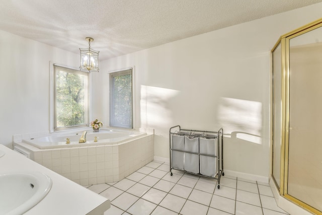 bathroom with tile patterned flooring, vanity, a textured ceiling, and plus walk in shower