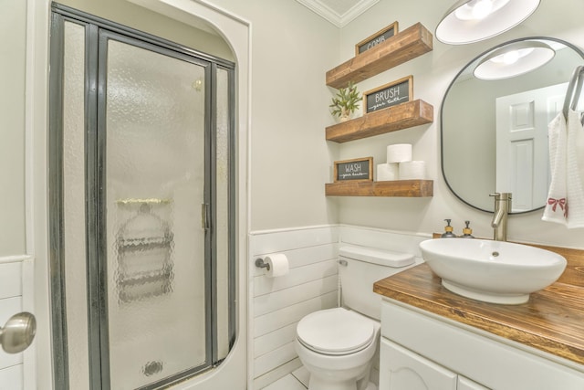 bathroom with ornamental molding, vanity, an enclosed shower, toilet, and tile walls