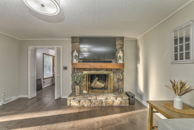 living room with a stone fireplace, dark wood-type flooring, a textured ceiling, and crown molding