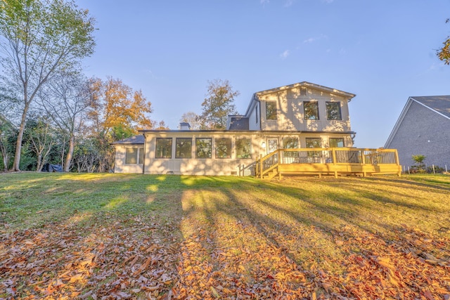 back of property featuring a sunroom, a lawn, and a wooden deck