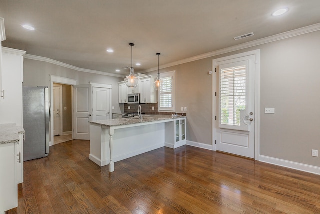 kitchen featuring light stone counters, dark hardwood / wood-style floors, kitchen peninsula, white cabinets, and appliances with stainless steel finishes