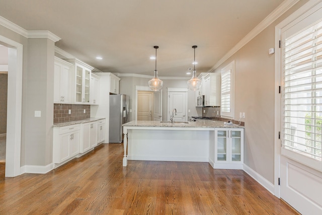 kitchen with white cabinets, light wood-type flooring, sink, and appliances with stainless steel finishes