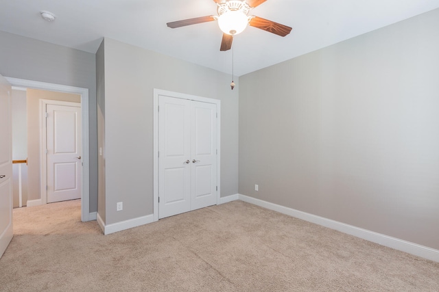 unfurnished bedroom with ceiling fan, light colored carpet, and a closet