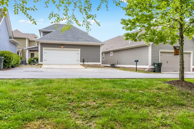 view of front of property featuring central AC unit, a garage, and a front yard