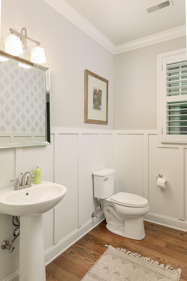 bathroom with crown molding, toilet, sink, and hardwood / wood-style flooring