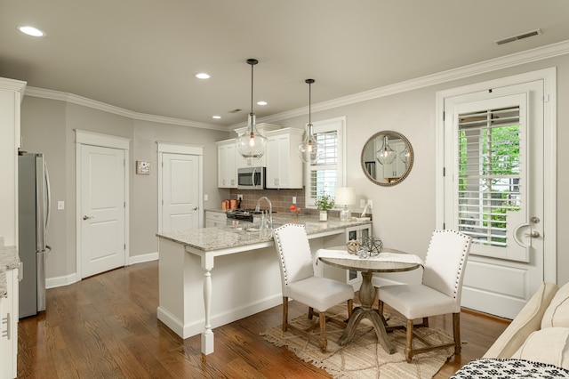 kitchen with white cabinets, appliances with stainless steel finishes, dark hardwood / wood-style flooring, and a wealth of natural light